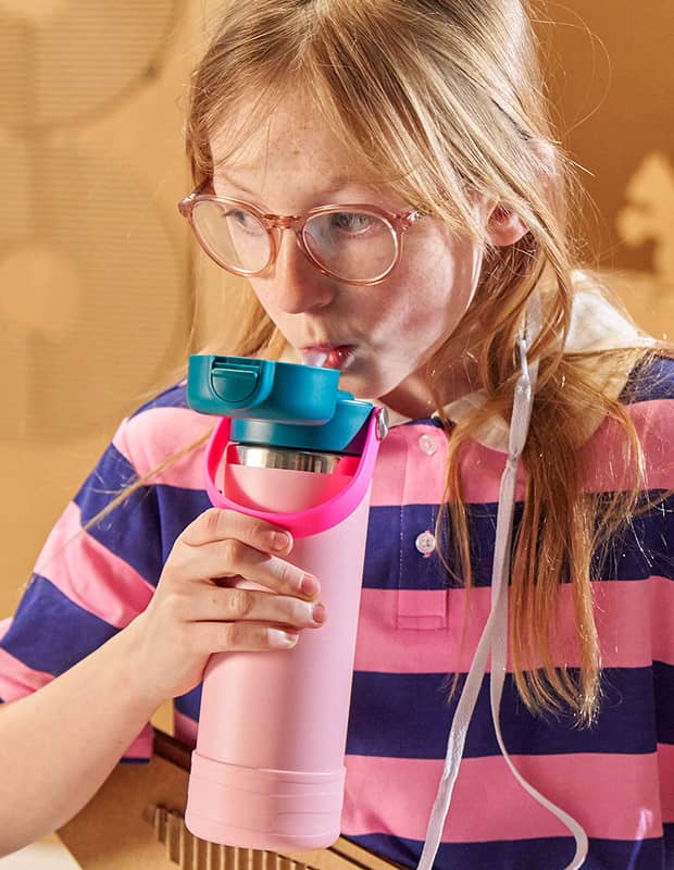 Child drinking from covered-cap bottle